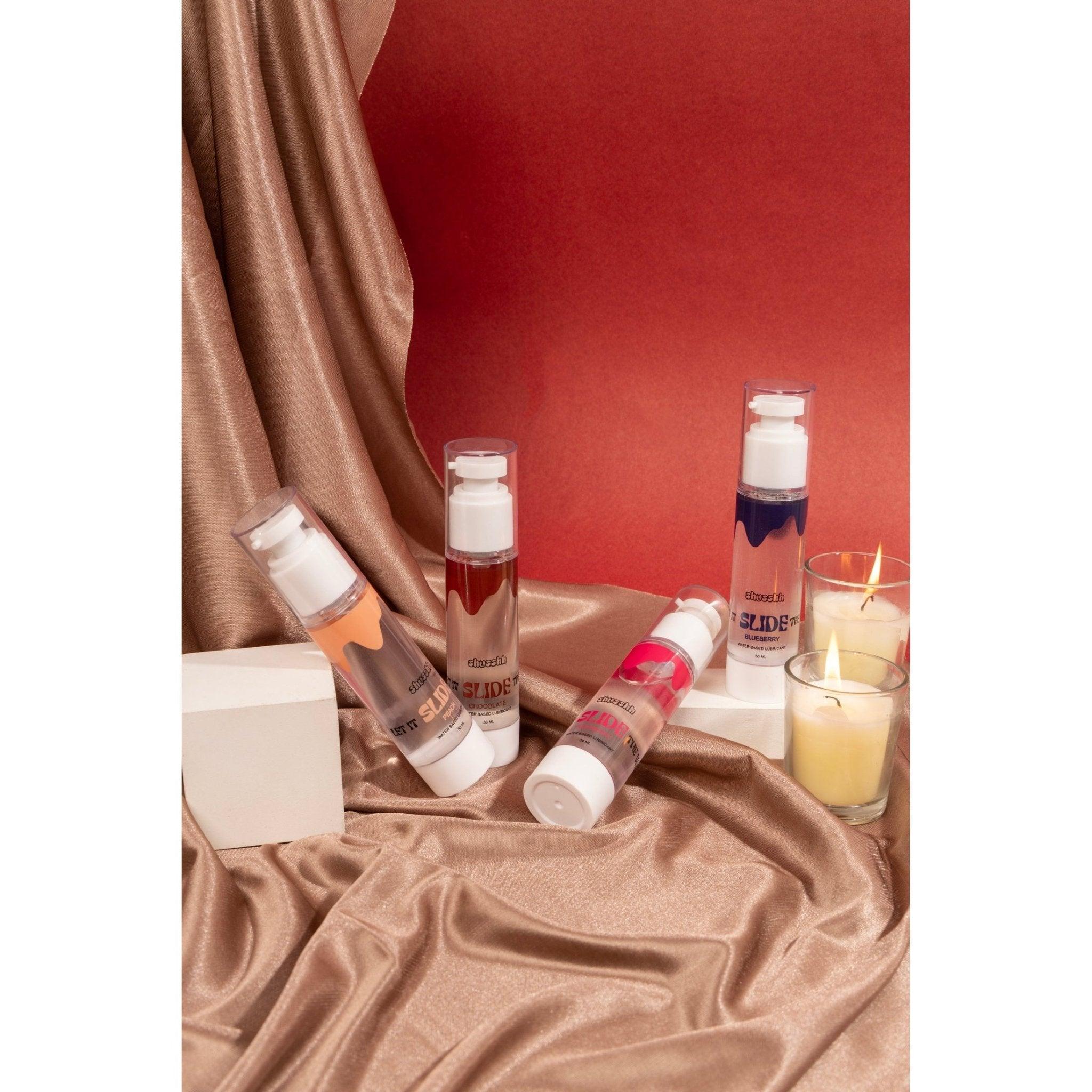 Assorted flavored lubricants with candlelight setup on silk fabric background